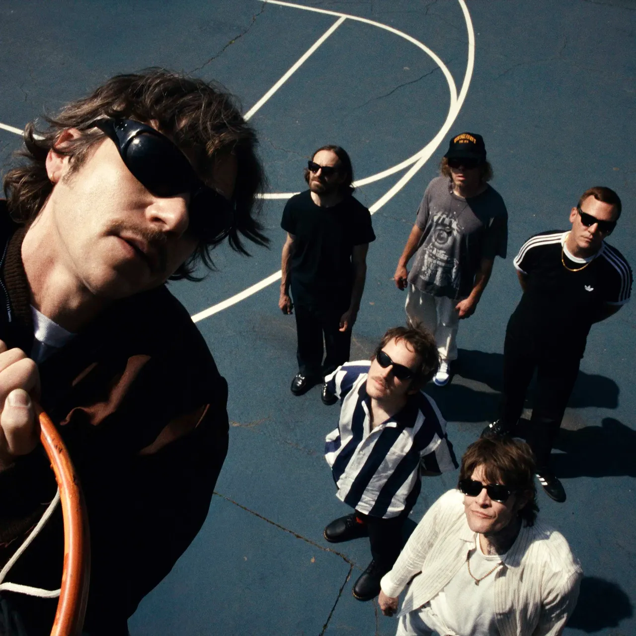 Cage The Elephant single artwork featuring the band members looking up at a basketball hoop on a blue outdoor court from a high-angle perspective.