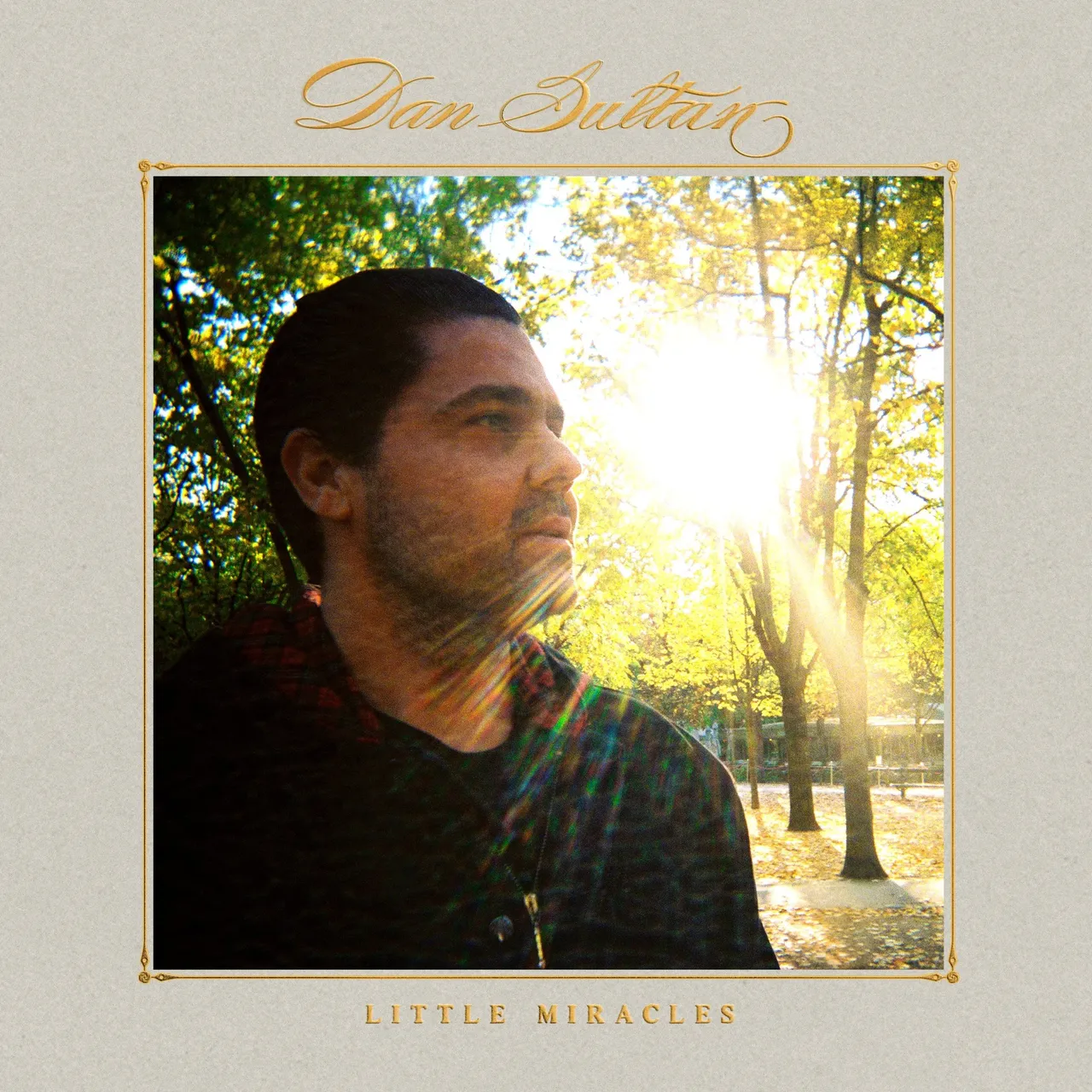 Dan Sultan Little Miracles album cover art featuring a profile portrait of the musician in a sunlit park with bright golden lens flare.
