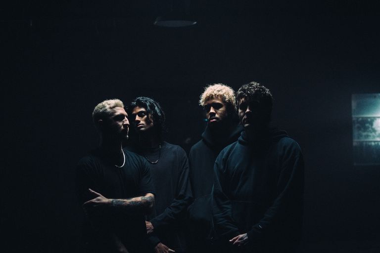 Moody press photo of Australian metalcore band HEAVENSGATE standing together in dark lighting wearing black clothing.