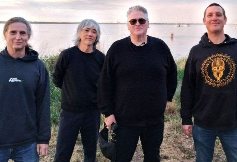 Australian punk rock band Hard-Ons posing outdoors near the water.