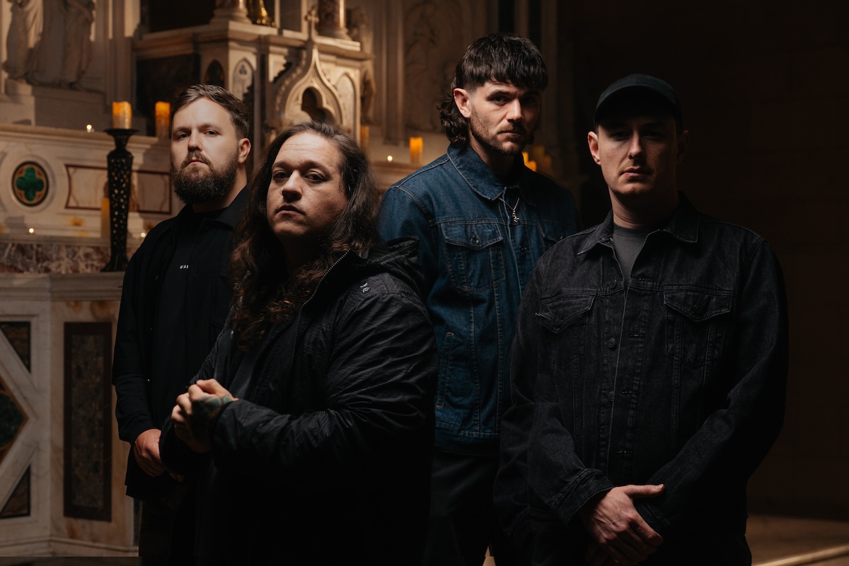 Promotional portrait of Australian metalcore band Polaris standing together inside a dimly lit church or cathedral setting.