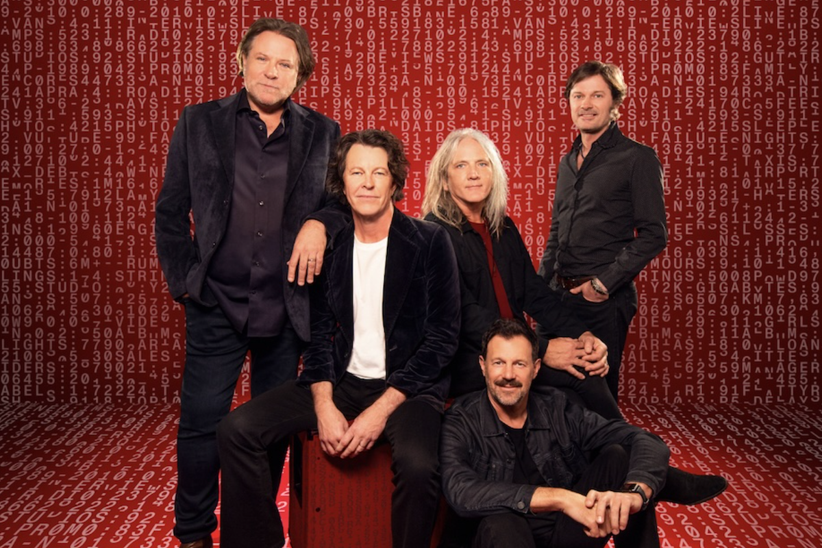 Australian rock band Powderfinger members pose together in dark outfits against a red backdrop filled with repeating digital numbers and letters.