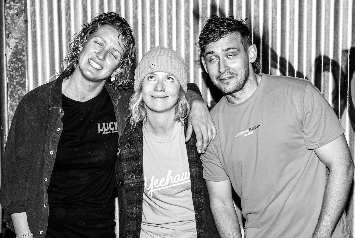 Black and white portrait of Australian punk rock trio RATSALAD. posing against a corrugated metal wall.