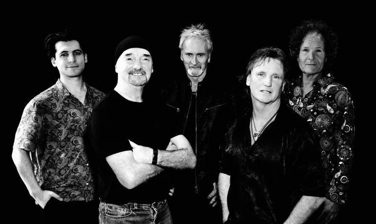 British rock band Smokie members posing together in a black and white studio promotional portrait against a dark background.